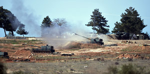 Eine Artilleriepanzer feuert unter Rauchschwaden einen Schuss ab