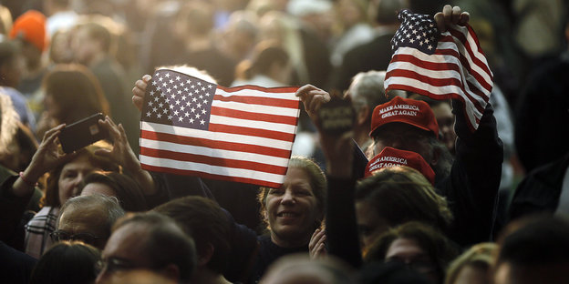 eine Menschenmenge, darin zwei US-amerikanische Flaggen