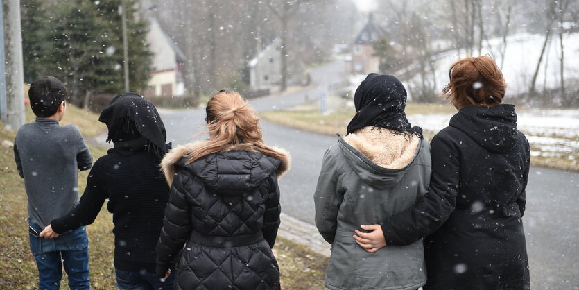 Fünf Menschen schauen auf eine Straße