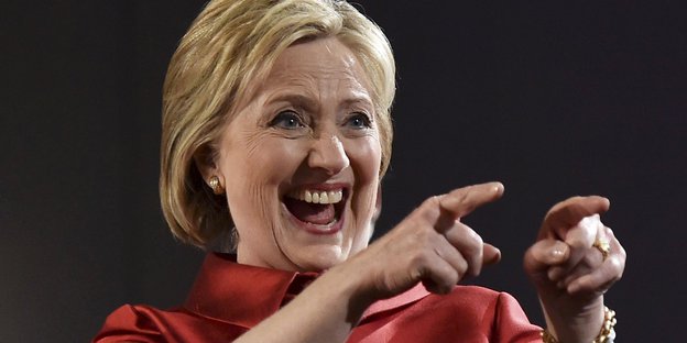 Hillary Clinton freut sich und zeigt auf etwas