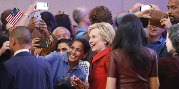 Hillary Clinton posiert mit einer jungen Frau für ein Foto