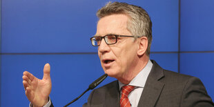 Innenminister De Maizière spricht in ein Mikrofon