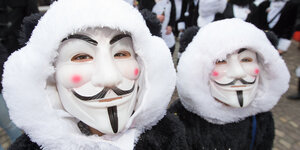 zwei Menschen mit Guy-Fawkes-Masken