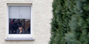 Ein Junge schaut aus einem Fenster