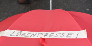 Roter Regenschirm mit der Aufschrift "Lügenpresse"