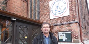 Pfarrer Matthias Gürtler vor einer Kirche