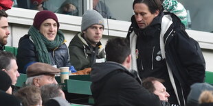 Fußballtrainer Roger Schmidt sucht einen Sitzplatz in einem Stadion.