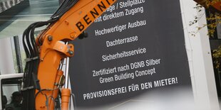 Bagger vor einem Bauschild