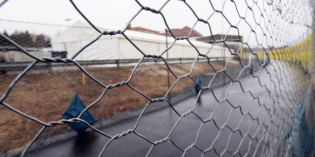 Blick durch einen Drahtzaun auf ein großes Zelt in Spielfeld an der österreichisch-slowenischen Grenze. Hier werden Ankömmlinge registriert.