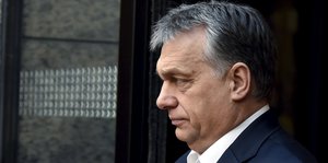 Viktor Orban steht mit nachdenklicher Miene vor einem Gebäude.