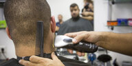 Filmszene: Einem Mann werden die Haare geschnitten