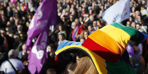 Menschen demonstrieren, im Vordergrund ein regenbogenfarbener Hut