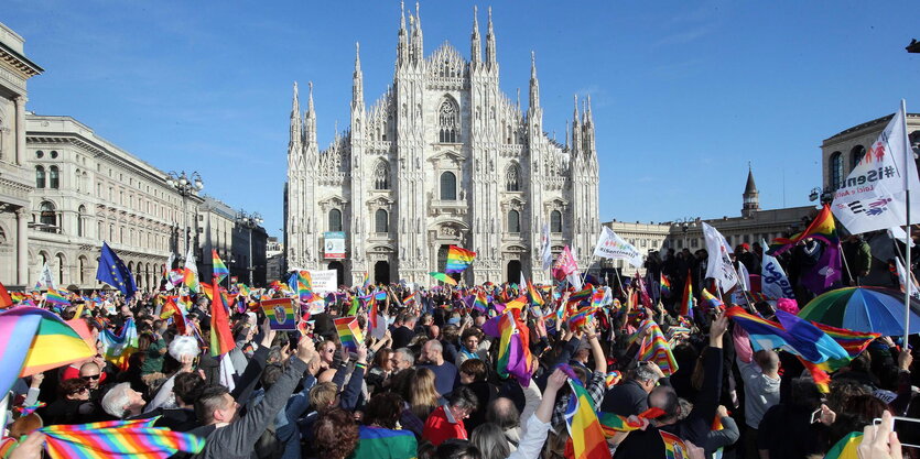 Menschen demonstrieren mit Regenbogenflaggen