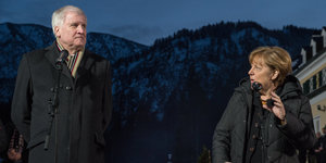 CSU-Chef Seehofer und Bundeskanzlerin Merkel vor Bergkulisse, beide tragen Wintermäntel