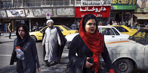 zwei Frauen (beide mit Kopftuch) und ein Mann (mit Turban) überqueren eine Straße