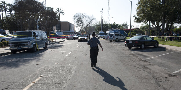 Eine Polizistin geht auf der Straße auf eine Absperrung zu