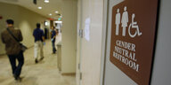Ein Schild weist in englischer Sprache auf genderneutrale Toiletten hin.