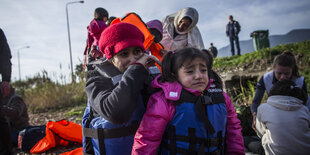 menschen erreichen im boot eine küste