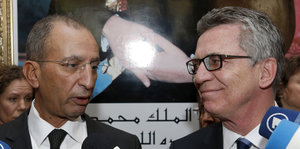 Thomas de Maizière und Mohamed Hassad schauen sich an.