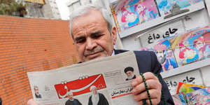 ein älterer Mann ließt eine Zeitung