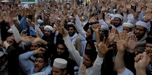 Pakistaner protestieren dicht gedrängt und mit erhobenen Händen.