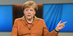 Angela Merkel mit erhobener Hand.