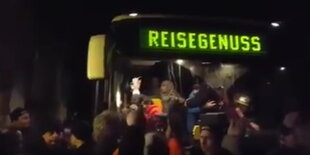 Menschen stehen vor einem Bus aus dem andere aussteigen