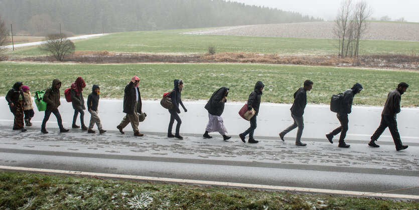 Menschen laufen in einer Reihe auf einer Straße