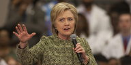 Hillary Clinton hält ein Mikrofon in der Hand.