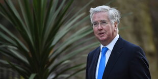 Verteidigungsminister Michael Fallon trägt einen Anzug.