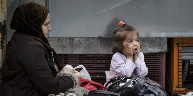 Ein Mädchen aus einer Flüchtlingsfamilie hält sich auf dem Victoiraplatz in Athen die Hände ans Gesicht.