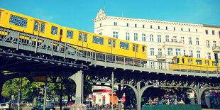 Eine gelbe Bahn fährt die Hochtrasse am Schlesischen Tor in Berlin entlang.