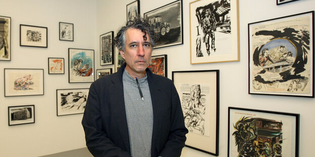 Der junge Raymond Pettibon steht vor Bildern seiner Ausstellung.