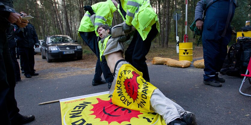 Ein Anti-AKW-Demonstrant wird von Polizisten weggezerrt.