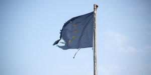 Eine zerrissene blaue EU-Fahne weht im Wind