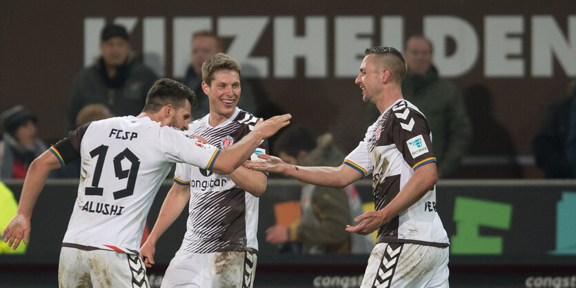 St. Pauli-Stürmer John Verhoek klatscht nach seinem Tor mit Enis Alushi ab, Daniel Buballa steht daneben und lacht.