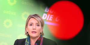 Simone Peter, Parteivorsitzende der Grünen, vor einer grünen Wand mit dem Parteilogo.