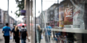 Zersplitterte Glasscheibe, dahinter Tabakwaren, an einer Einkaufsstraße