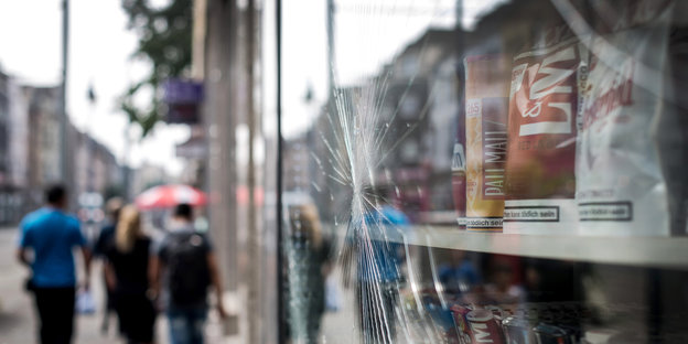Zersplitterte Glasscheibe, dahinter Tabakwaren, an einer Einkaufsstraße