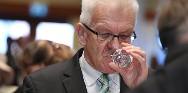 Winfried Kretschmann trinkt aus einem Glas