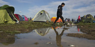 EIn Junge läuft durch Flüctlingszeltlager an der griechisch-mazedonischen Grenze