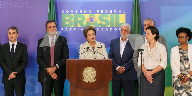 Brasiliens Präsidentin Rousseff steht vor einem Podium. Um sie stehen weitere Personen.