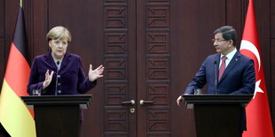 Angela Merkel und Ahmet Davutoglu stehen an Rednerpulten vor den Flaggen der beiden Länder.