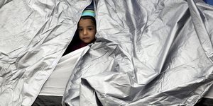 Ein Kind guckt aus einem Zelt heraus
