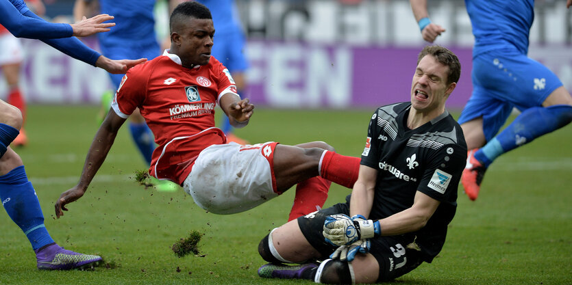 Der Mainzer Jhon Cordoba (l) im Tweikampf mit Darmstadts Keeper Christian Mathenia.