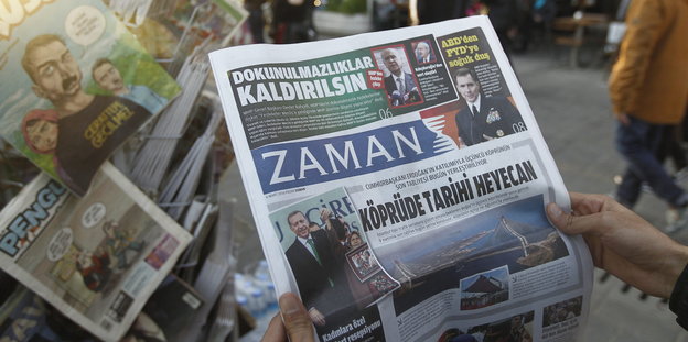 Ein mensch hält die Zaman-Zeitung in der Hand. Auf dem Titel natürlich: Erdogan