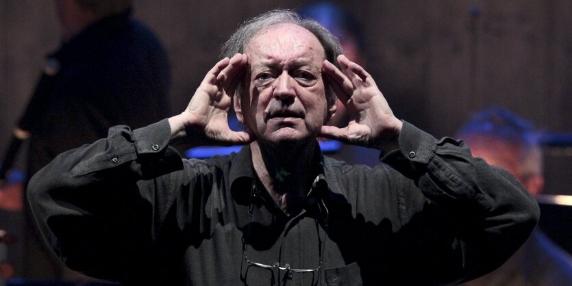 Nikolaus Harnoncourt fasst sich mit den Händen an den Kopf.