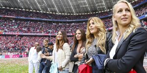 Frauen mit langen Haaren stehen auf einem Fußballfeld