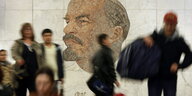 Verwischte Gestalten vor einem Mosaik von Lenin in der Moskauer U-Bahn