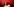 Jemand bewegt sich vor einem roten Hintergrund. Das Bild ist verschwommen.